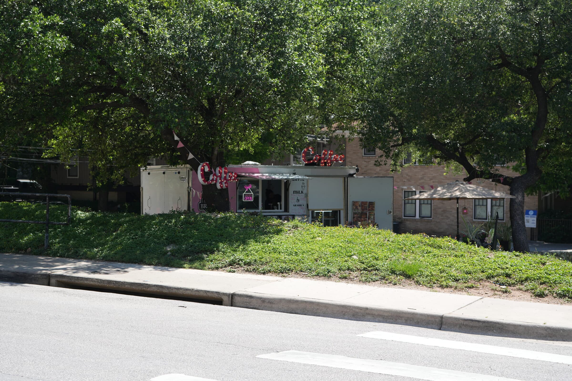 Wide view across the ANW lot toward the on-lot coffee truck with cars parked along the back