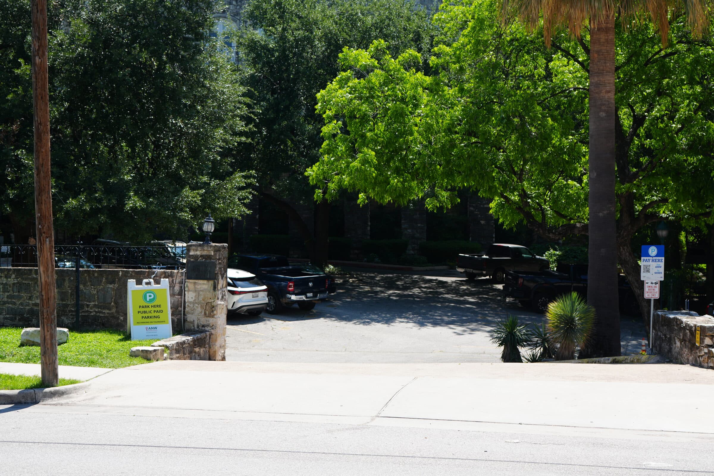Wide view of the ANW lot entrance under the shade of a mature tree canopy