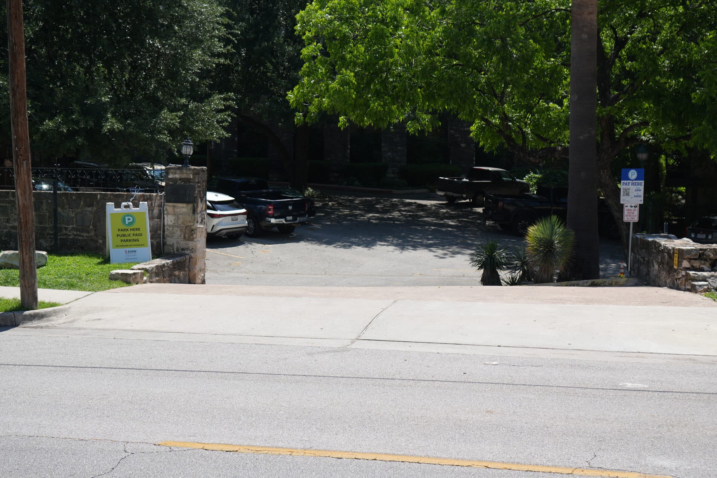 The ANW Parking lot entrance on Nueces Street, with the public parking sign and shaded canopy
